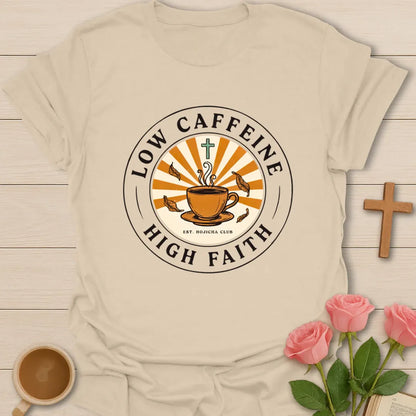Low Caffeine High Faith shirt with Hojicha tea cup, sunburst, cross, falling leaves, and circular badge design. - Sand