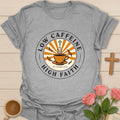 Low Caffeine High Faith shirt with Hojicha tea cup, sunburst, cross, falling leaves, and circular badge design. - Sport Grey