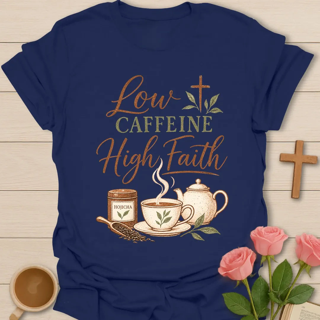 Low Caffeine High Faith t-shirt with script and vintage lettering, a hojicha tea tin, teacup, teapot and a cross made of tea leaves. - Navy