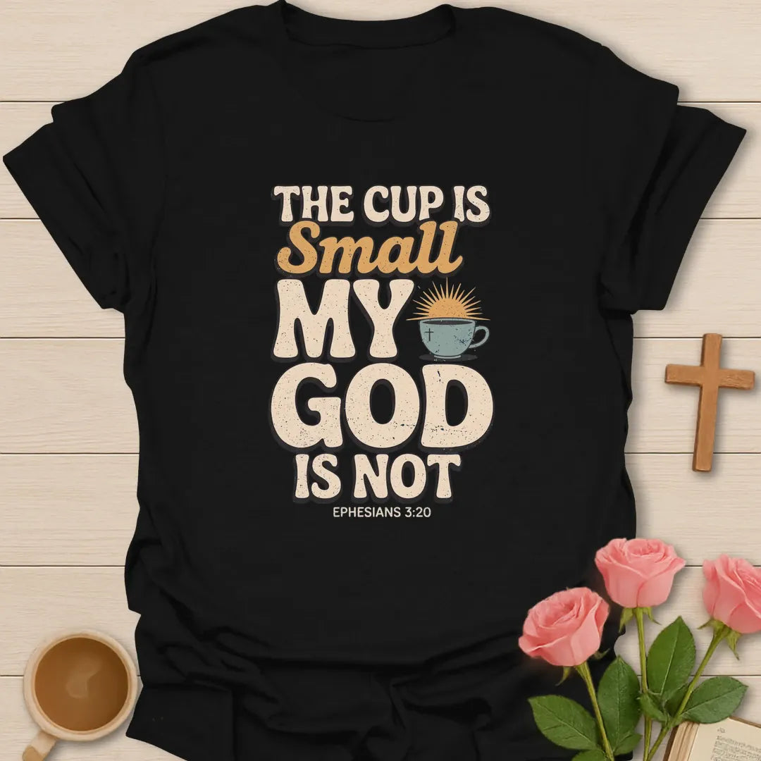 The Cup Is Small My God Is Not Christian t-shirt with bold lettering, a teacup with a cross and sunrise, and Ephesians 3:20 - Black