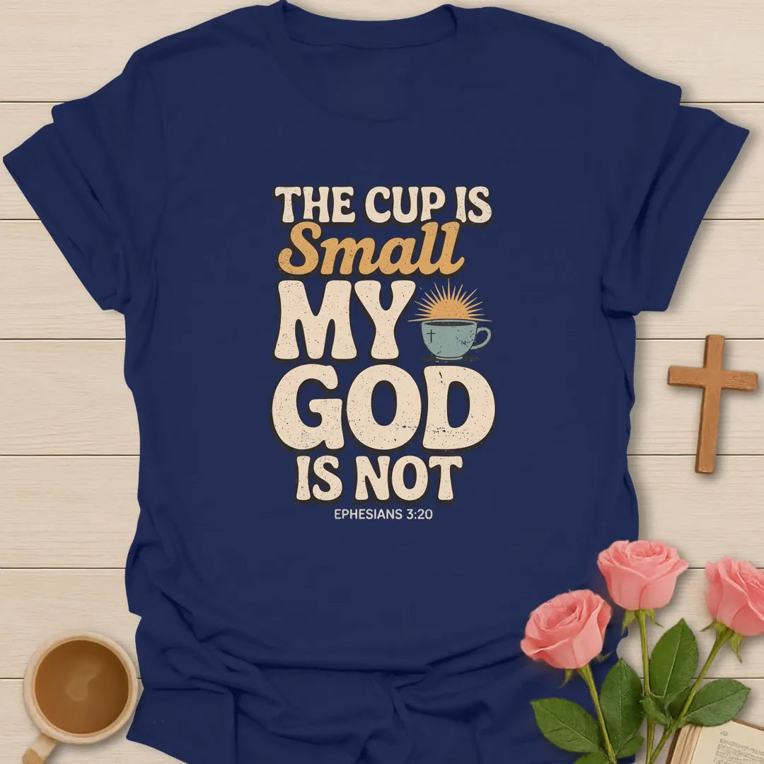 The Cup Is Small My God Is Not Christian t-shirt with bold lettering, a teacup with a cross and sunrise, and Ephesians 3:20 - Navy
