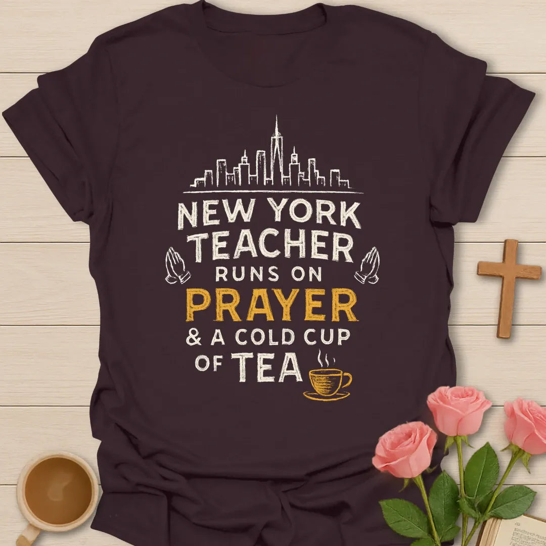 New York Teacher Runs On Prayer shirt with skyline, praying hands, distressed cream lettering, gold prayer text, and small teacup. - Dark Chocolate