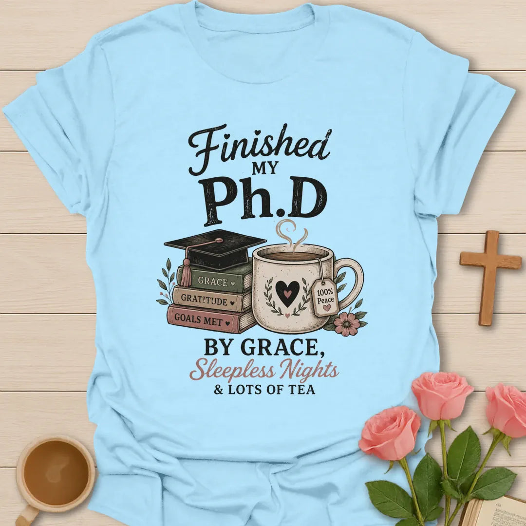 Ph.D Finished graduation shirt with graduation cap, faith message, and 2 Timothy 4:7 text. - Light Blue