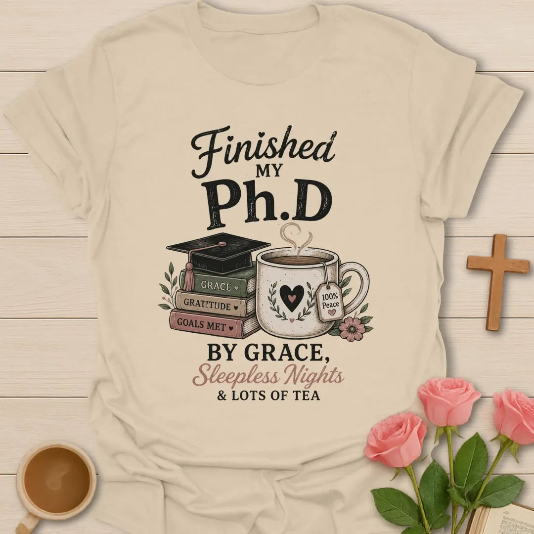 Ph.D Finished graduation shirt with graduation cap, faith message, and 2 Timothy 4:7 text. - Sand