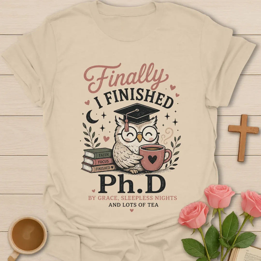 Ph.D and Lots of Tea shirt with graduation cap, teacup, and faith-inspired typography. - Sand
