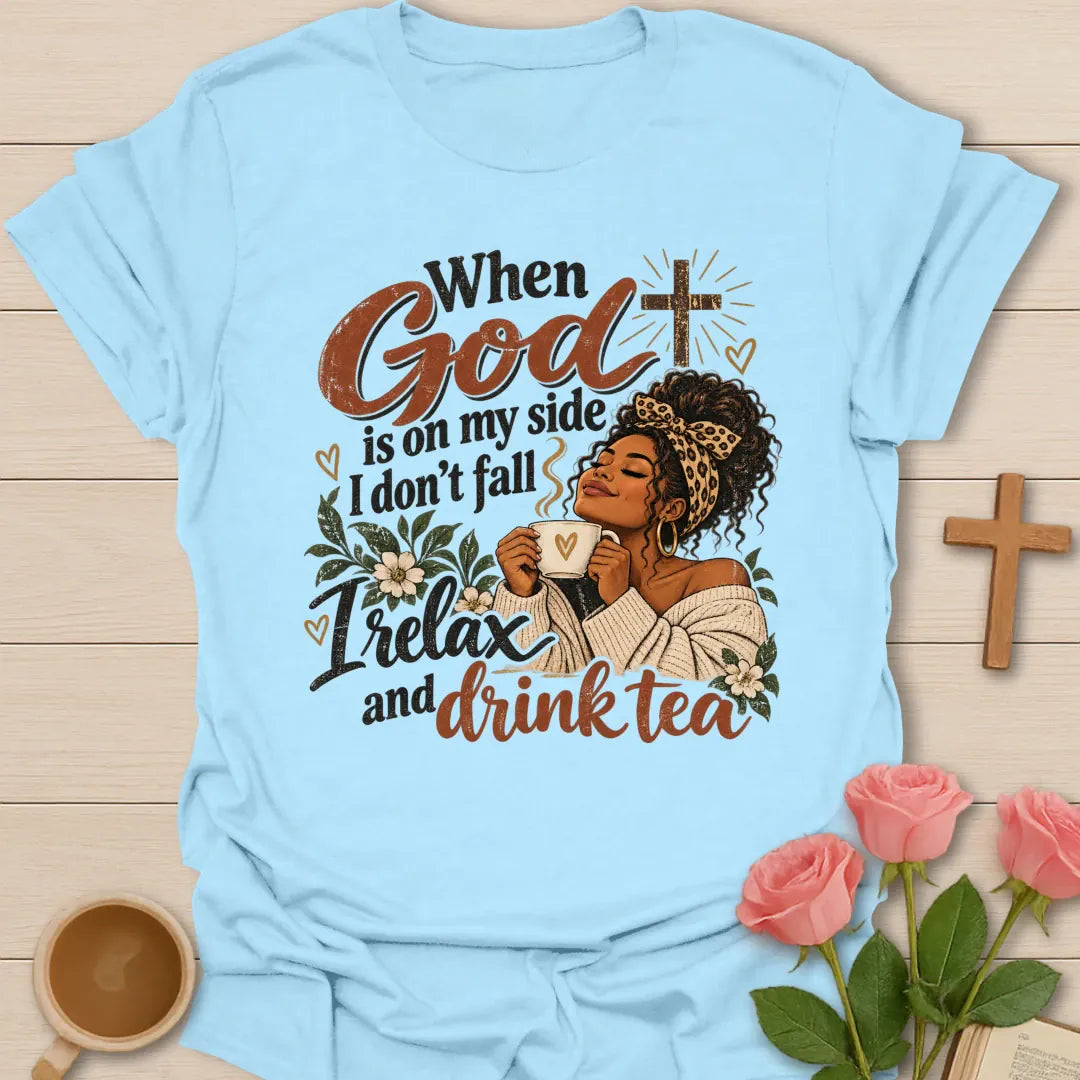 When God Is On My Side I Don't Fall, I Relax And Drink Tea Christian t-shirt with a woman in a leopard headband holding a teacup beside a glowing cross - Light Blue