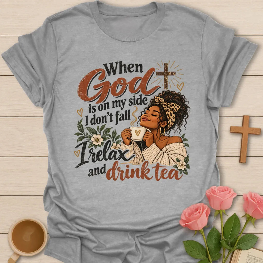 When God Is On My Side I Don't Fall, I Relax And Drink Tea Christian t-shirt with a woman in a leopard headband holding a teacup beside a glowing cross - Sport Grey