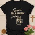 Sippin Tea and Standin Firm shirt with mason jar iced tea, cross tea tag, straw, and vintage cream typography. - Black