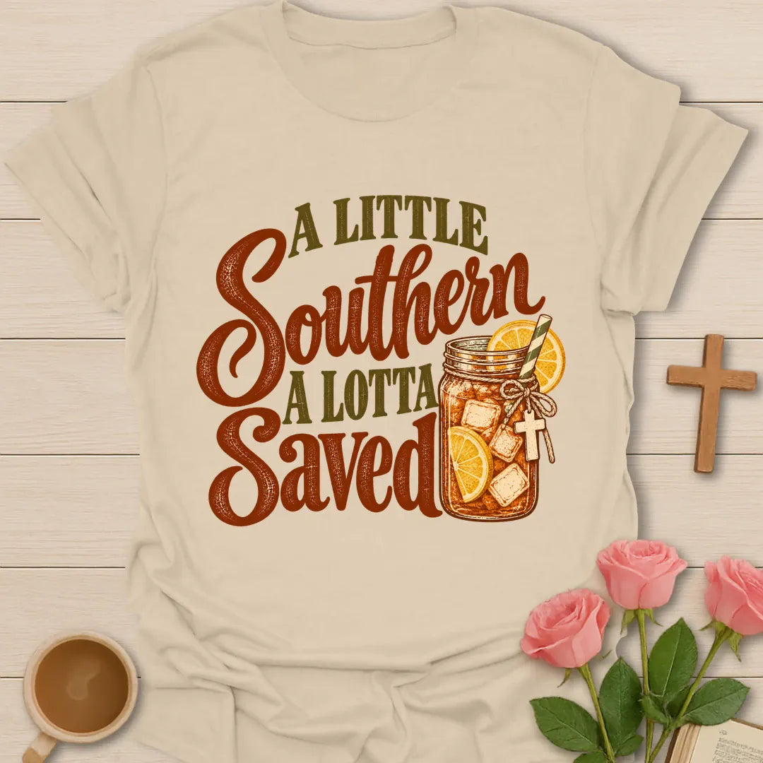 A Little Southern A Lotta Saved Christian t-shirt with rust script lettering and a mason jar of lemon sweet tea with a cross - Sand