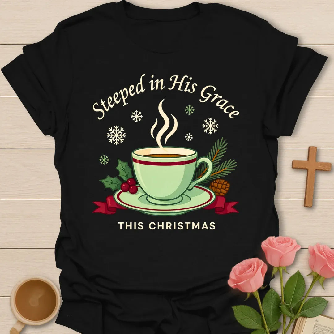 Steeped in His Grace Christmas shirt with green teacup, holly, pine, snowflakes, and cream lettering. - Black