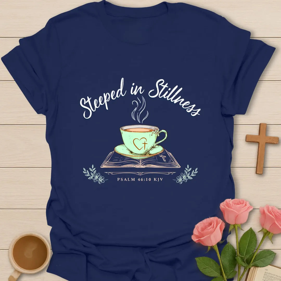 Steeped In Stillness Christian tea shirt with teacup, open Bible, floral accents, and Psalm 46:10 text. - Navy