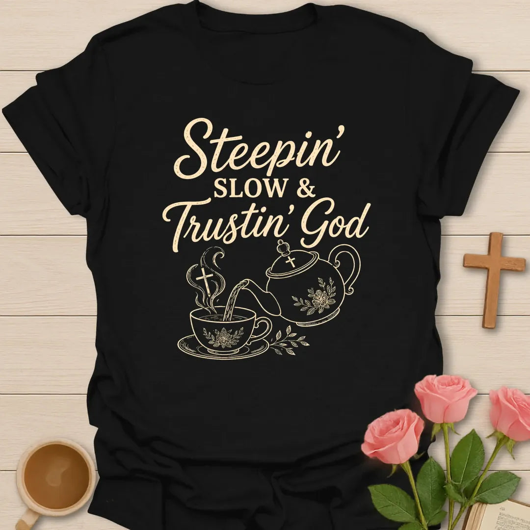 Steepin Slow and Trustin God shirt with teapot pouring tea, teacup, cross steam, floral line art, and cream lettering. - Black