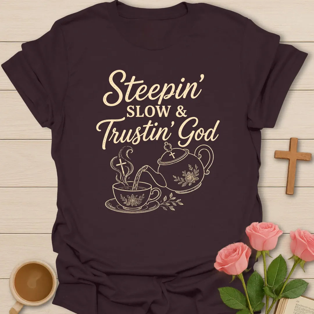 Steepin Slow and Trustin God shirt with teapot pouring tea, teacup, cross steam, floral line art, and cream lettering. - Dark Chocolate