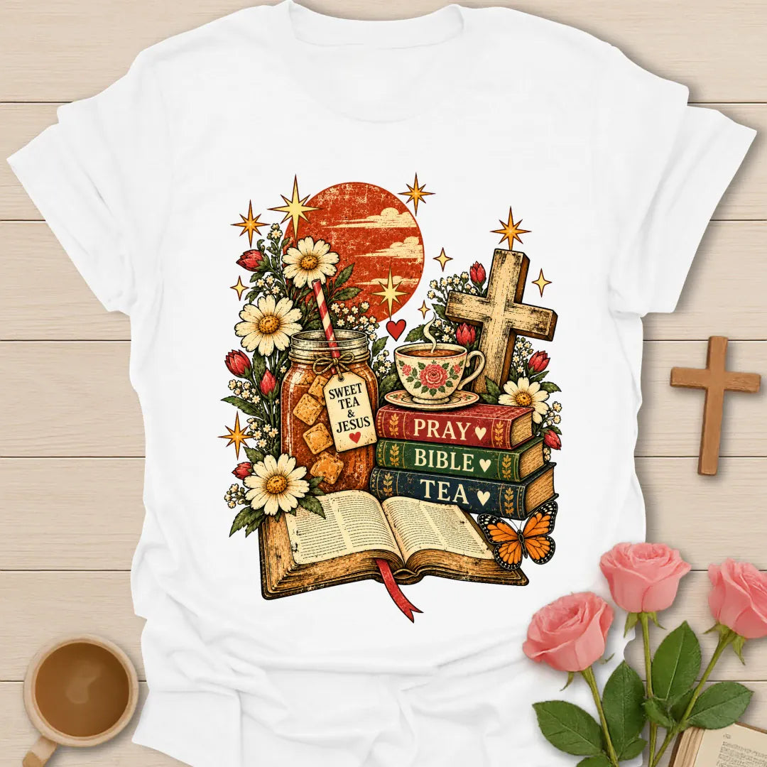 Tea Bible & Blooms t-shirt with an open Bible, a Pray Bible Tea book stack, a Sweet Tea & Jesus jar, a teacup, a wooden cross, daisies and a butterfly - White