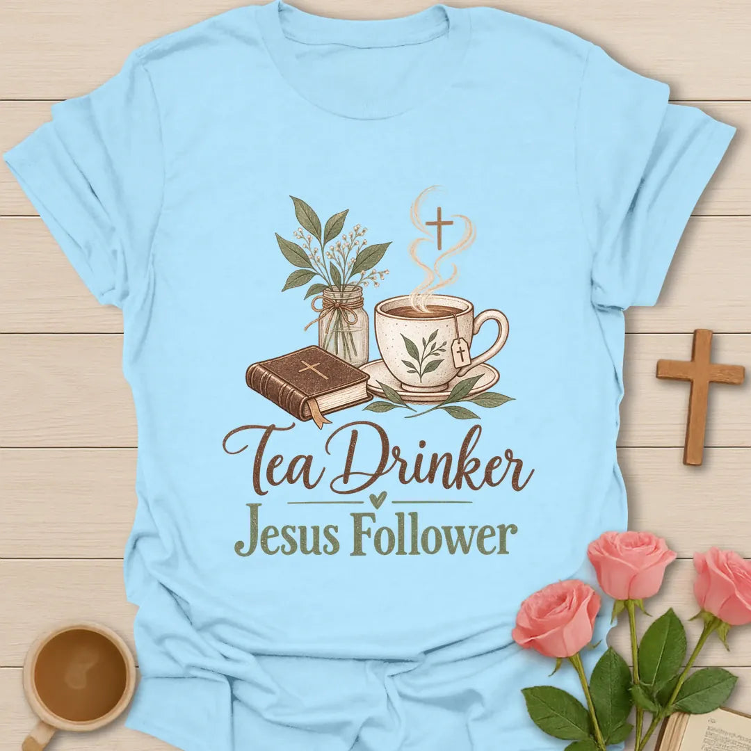 Tea Drinker Jesus Follower t-shirt with script lettering, a Bible, a teacup with cross-shaped steam and a jar of greenery. - Light Blue
