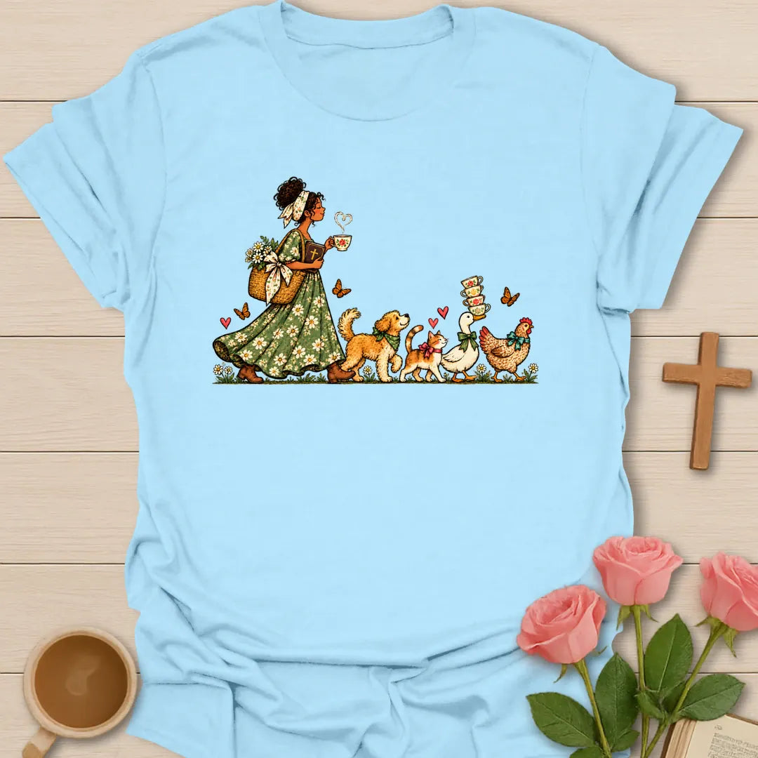 Tea-Time Parade t-shirt with a woman in a floral dress holding a teacup, followed by a dog, a cat, a goose and a chicken carrying teacups - Light Blue