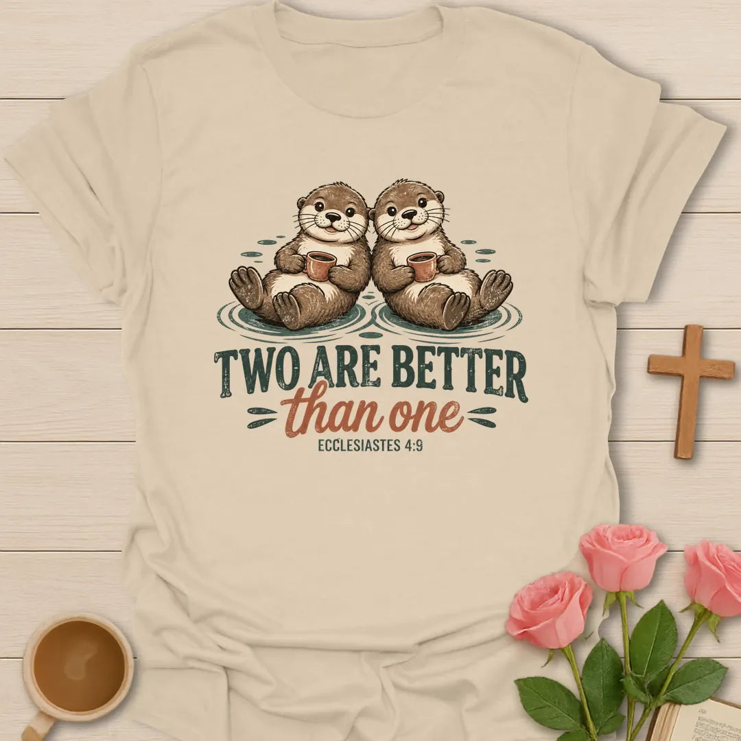 Two Are Better Than One Christian t-shirt with two smiling otters floating side by side holding mugs and Ecclesiastes 4:9 - Sand